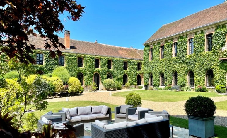 Salon de jardin extérieur du Séminaire proche Paris avec vue sur la bâtisse en lierre