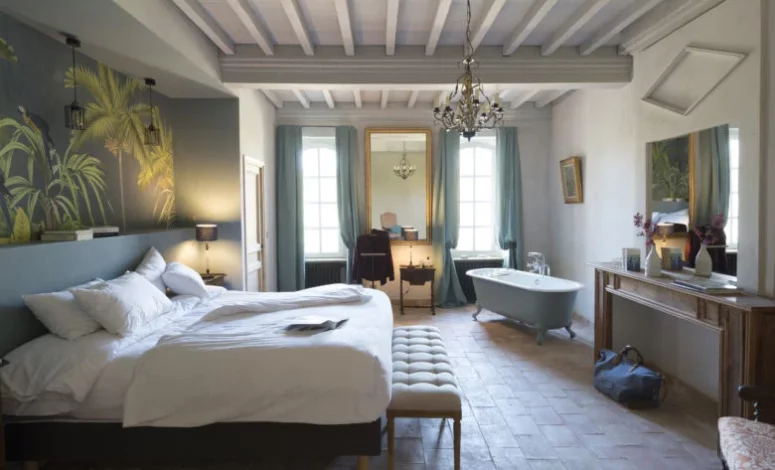 Chambre avec lit double, décoration soignée et lumière naturelle pour un Séminaire au vert proche de Toulouse