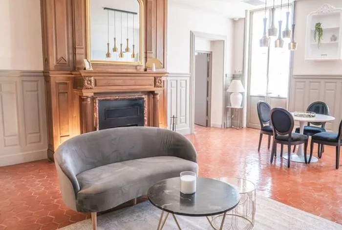 Salon élégant aux tons gris avec cheminée d'origine