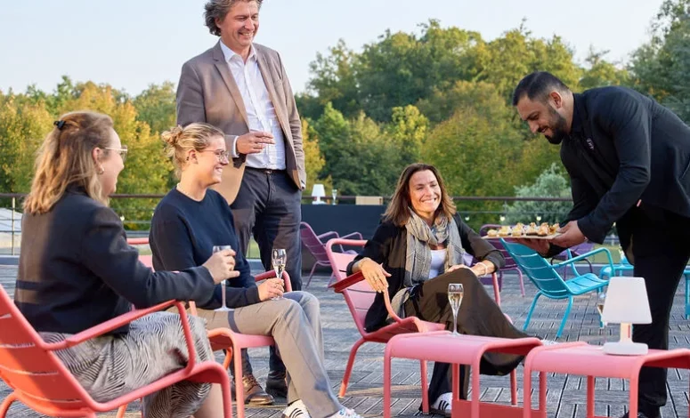 Echanges entre participants sur la terrasse lors d'un moment convivial en séminaire d'entreprise