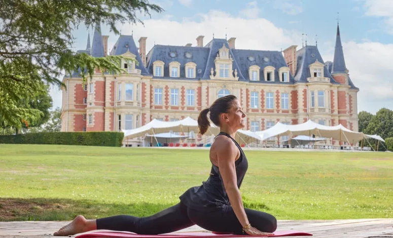 Séance de yoga en plein air devant le château, bien-être en séminaire au vert