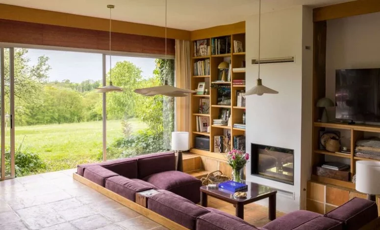 Salon avec cheminée et vue sur le jardin dans une maison de campagne
