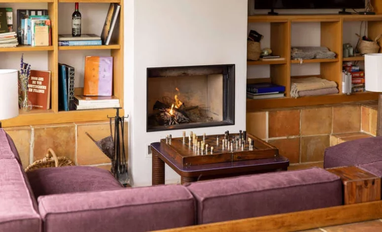Salon chaleureux avec bibliothèque et cheminée pour 15 personnes en séminaire
