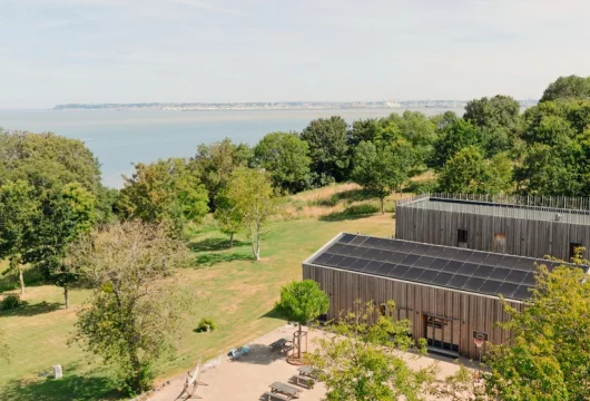 Vue aérienne des bâtiments et de la terrasse au milieu d’un vaste jardin arboré